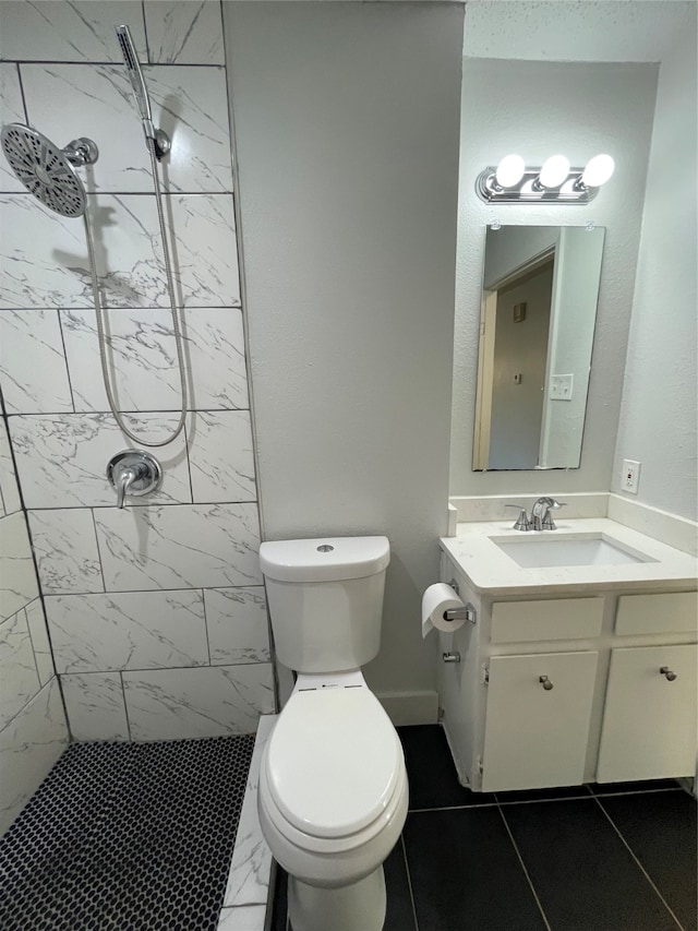 bathroom featuring vanity, toilet, tile patterned flooring, and a tile shower