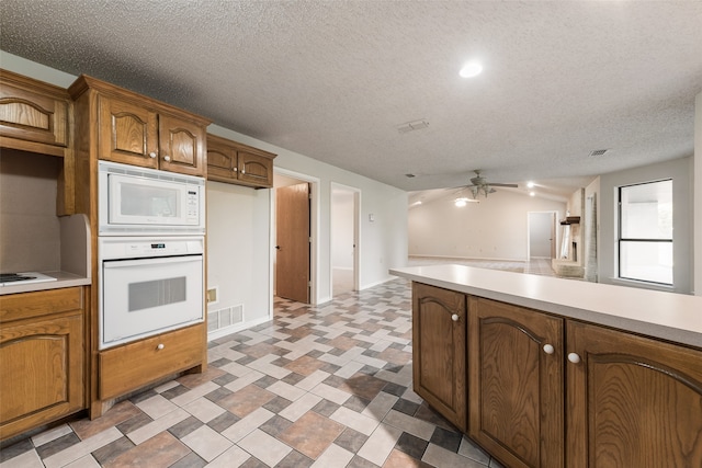 kitchen with a textured ceiling, ceiling fan, and white appliances