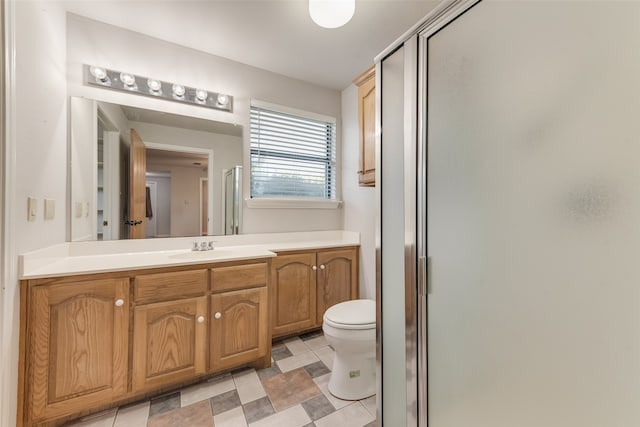 bathroom featuring vanity, walk in shower, and toilet