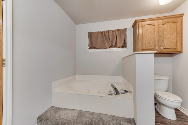 bathroom featuring toilet, a tub to relax in, and hardwood / wood-style floors