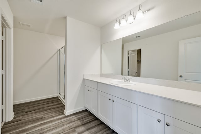 bathroom featuring wood-type flooring, vanity, and a shower with shower door