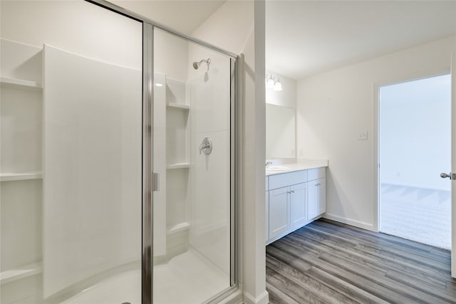 bathroom featuring hardwood / wood-style flooring, a shower with door, and vanity