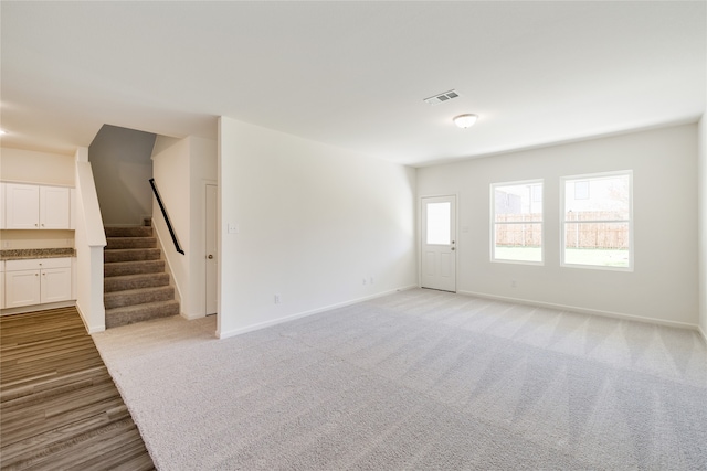 unfurnished living room with light colored carpet