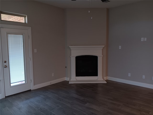 unfurnished living room with ceiling fan and dark hardwood / wood-style flooring