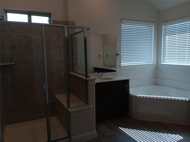 bathroom featuring vanity, plus walk in shower, hardwood / wood-style floors, and lofted ceiling