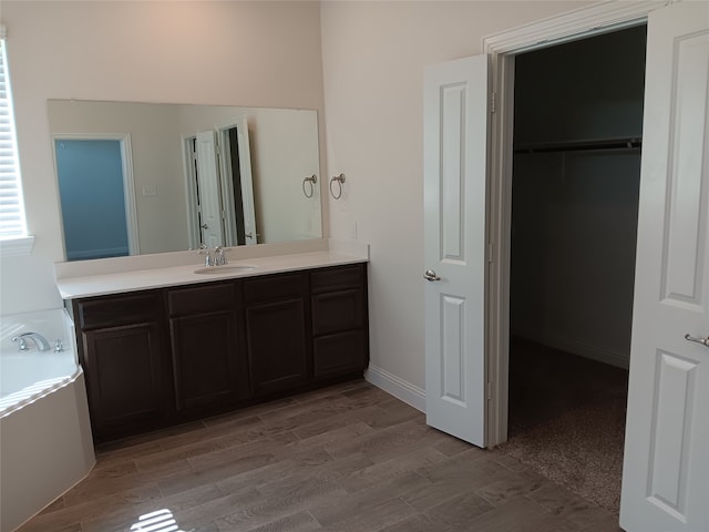 bathroom with vanity, hardwood / wood-style floors, and a washtub