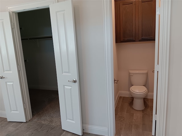 bathroom featuring wood-type flooring and toilet