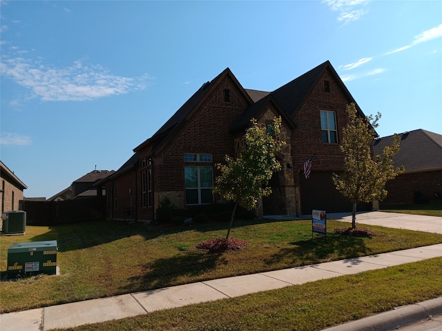 view of front of house with a garage, a front yard, and central AC unit