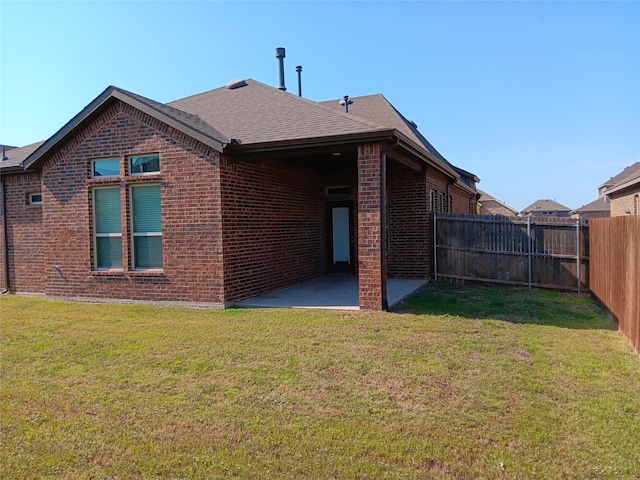 rear view of house featuring a patio and a lawn