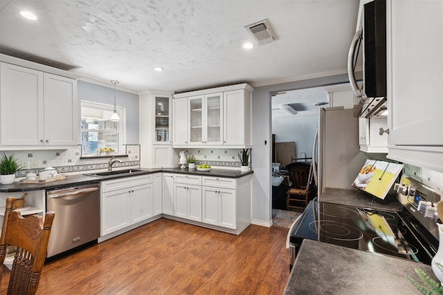 kitchen featuring white cabinets, stainless steel appliances, pendant lighting, and dark hardwood / wood-style flooring