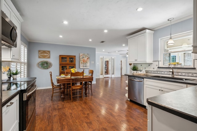 kitchen featuring appliances with stainless steel finishes, white cabinetry, sink, and dark wood-type flooring