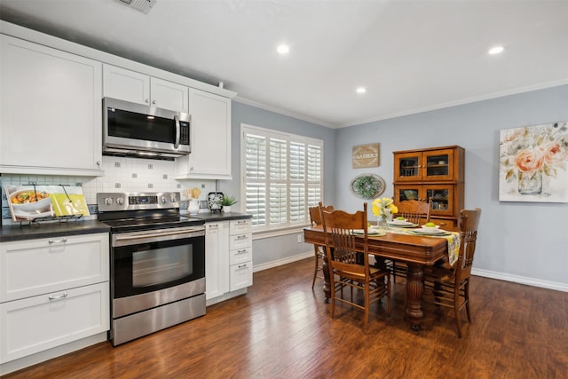 kitchen with dark hardwood / wood-style flooring, tasteful backsplash, white cabinetry, appliances with stainless steel finishes, and crown molding