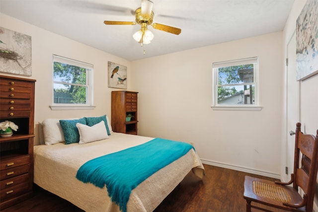 bedroom with multiple windows, dark hardwood / wood-style flooring, and ceiling fan