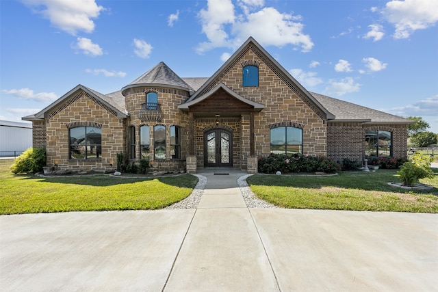 french country home with a front yard and french doors