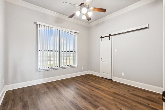 spare room with ornamental molding, ceiling fan, dark hardwood / wood-style floors, and a barn door