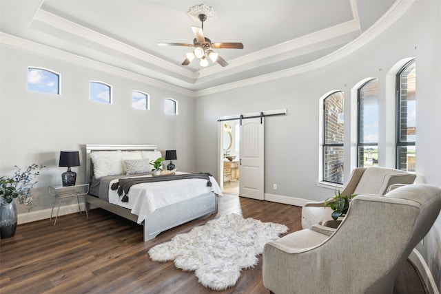 bedroom featuring ceiling fan, a tray ceiling, dark hardwood / wood-style floors, and a barn door