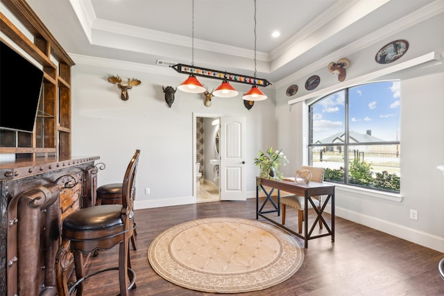 interior space featuring dark hardwood / wood-style floors, a tray ceiling, and ornamental molding