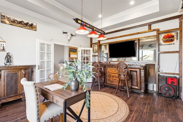 dining room featuring a tray ceiling, bar, dark hardwood / wood-style floors, and ornamental molding