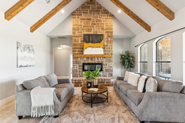 living room featuring tile patterned floors, a fireplace, beamed ceiling, and high vaulted ceiling