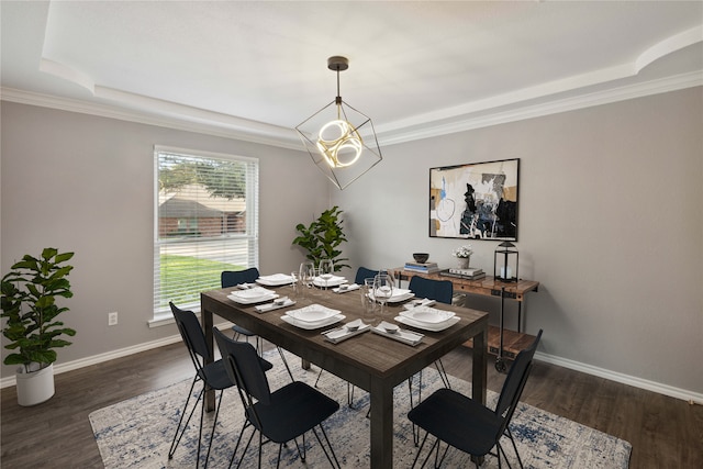 dining space with a chandelier, dark hardwood / wood-style floors, a raised ceiling, and ornamental molding