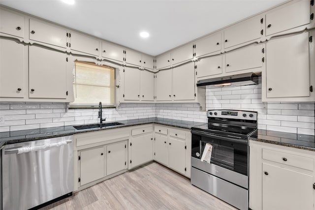 kitchen featuring sink, white cabinets, light hardwood / wood-style flooring, stainless steel appliances, and backsplash