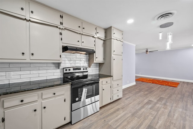 kitchen featuring dark stone countertops, white cabinetry, tasteful backsplash, stainless steel range with electric stovetop, and light wood-type flooring