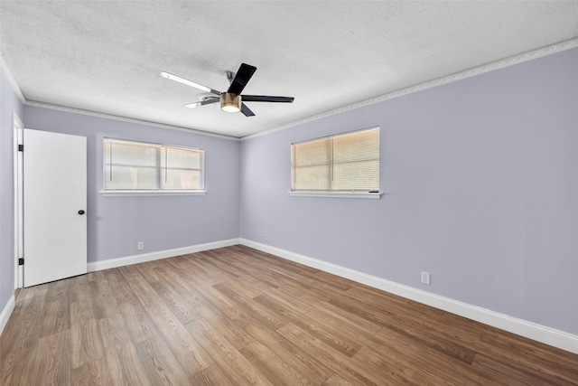 empty room featuring ceiling fan, a textured ceiling, light wood-type flooring, and crown molding