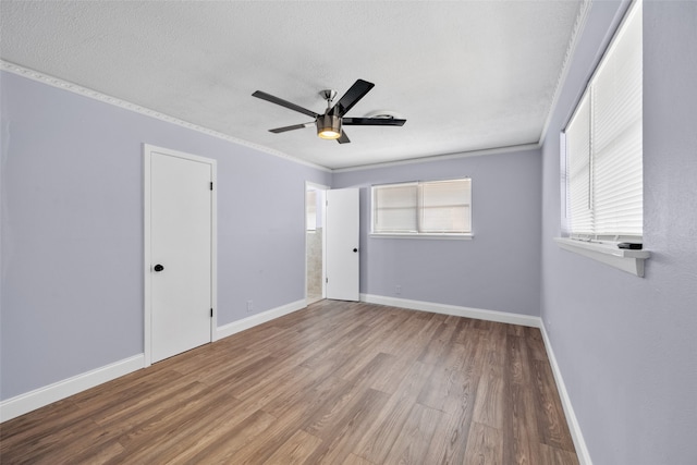 unfurnished room with ornamental molding, wood-type flooring, ceiling fan, and a textured ceiling