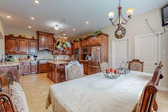 tiled dining area with sink and a chandelier