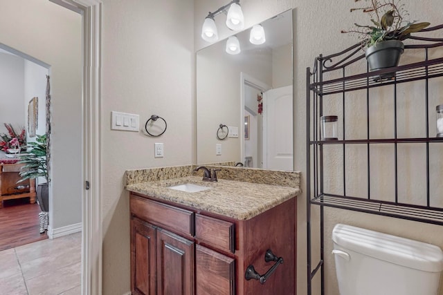 bathroom with wood-type flooring, vanity, and toilet