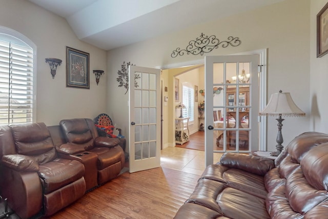 living room featuring french doors, hardwood / wood-style flooring, vaulted ceiling, and a healthy amount of sunlight