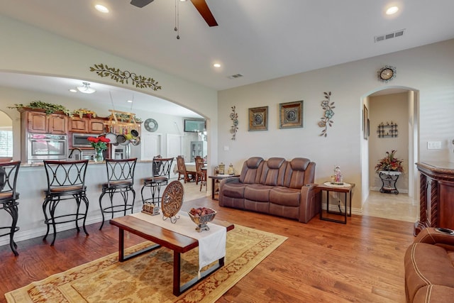 living room featuring light wood-type flooring and ceiling fan