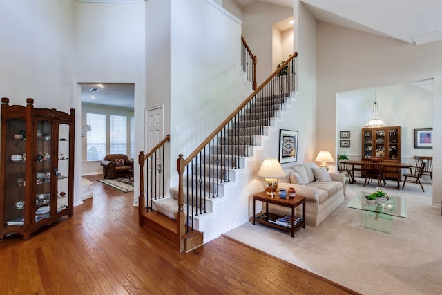 stairway featuring a high ceiling and hardwood / wood-style floors