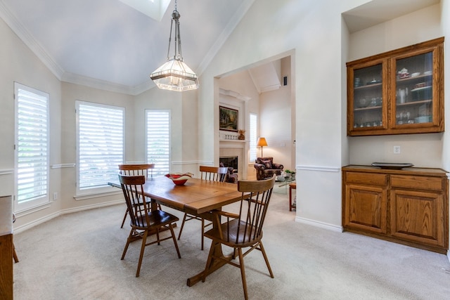 dining area featuring light carpet, lofted ceiling, and ornamental molding