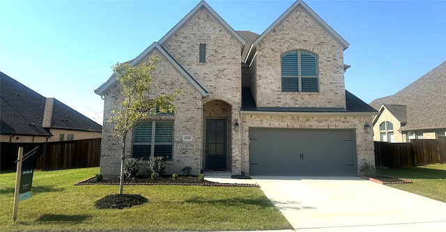 view of front of property with a garage and a front lawn