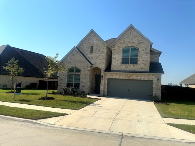 french provincial home with a front yard and a garage