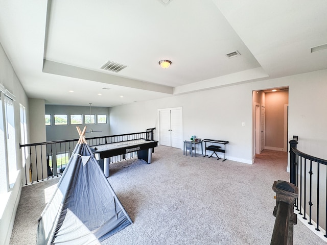 playroom featuring a tray ceiling and carpet floors