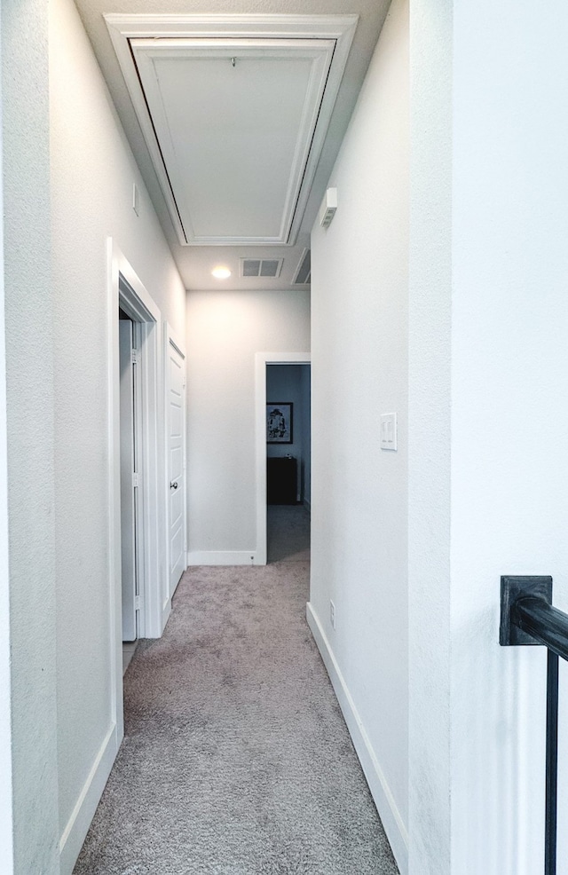 hallway featuring light colored carpet