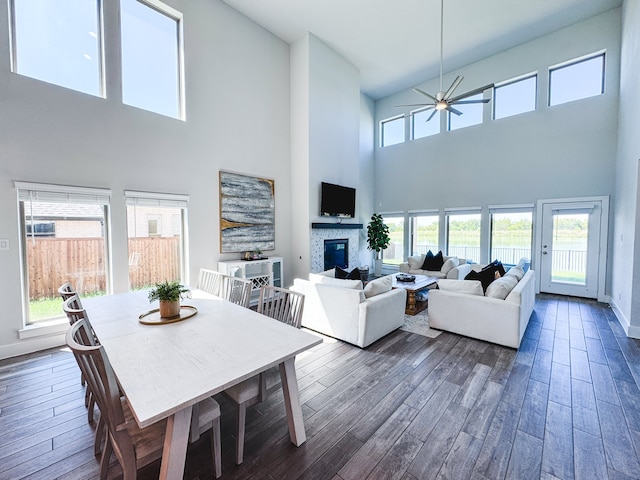 living room with a wealth of natural light, dark hardwood / wood-style floors, and a towering ceiling