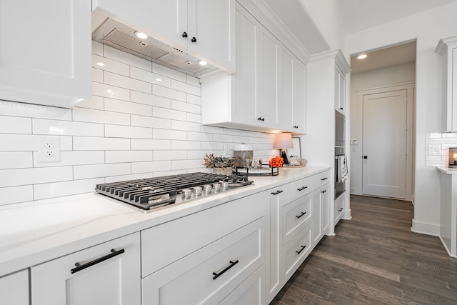 kitchen featuring dark wood-type flooring, light stone counters, tasteful backsplash, white cabinets, and stainless steel appliances