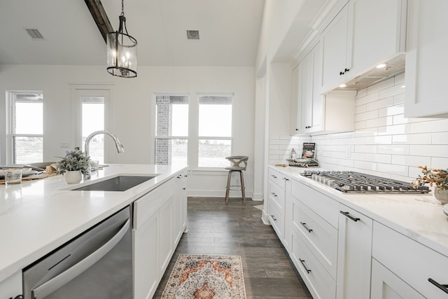 kitchen featuring white cabinetry, dark hardwood / wood-style flooring, stainless steel appliances, decorative light fixtures, and sink