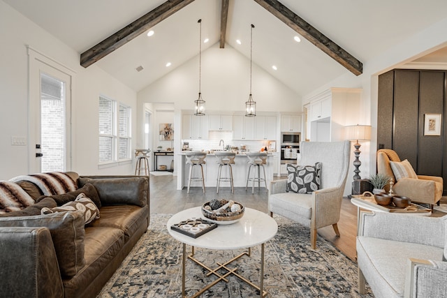 living room with beamed ceiling, hardwood / wood-style flooring, and sink