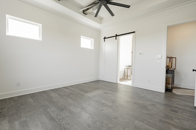 unfurnished room featuring ceiling fan, crown molding, a barn door, and dark hardwood / wood-style flooring