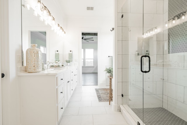 bathroom with ceiling fan, vanity, ornamental molding, a shower with shower door, and tile patterned flooring