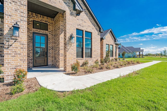 doorway to property featuring a lawn