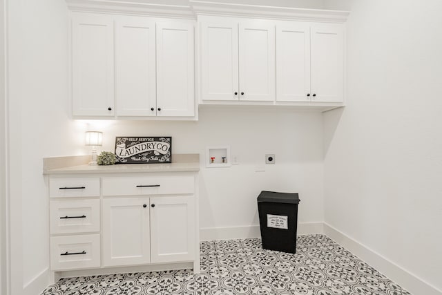 washroom featuring light tile patterned floors, washer hookup, electric dryer hookup, and cabinets