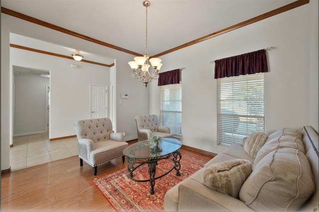 living room with light wood-type flooring, ornamental molding, and a notable chandelier