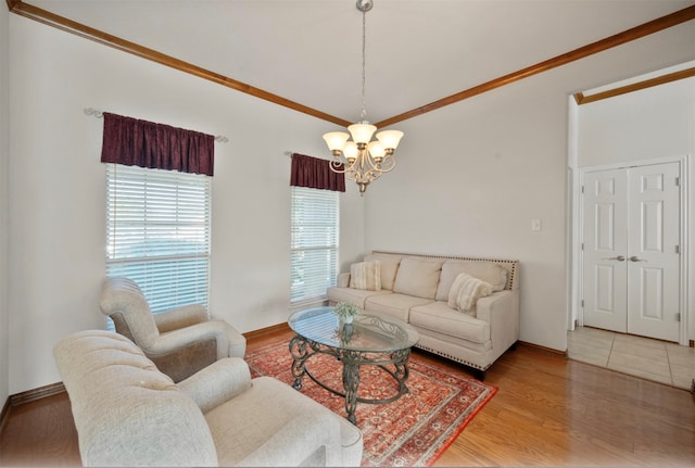 living room with wood-type flooring, crown molding, and a chandelier