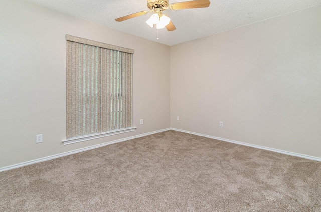 carpeted spare room featuring ceiling fan and a textured ceiling