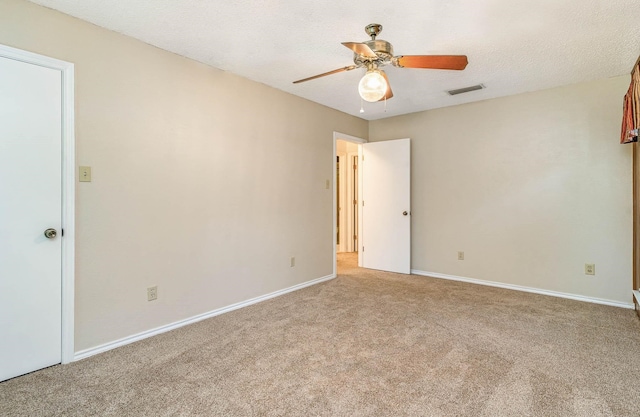 carpeted spare room featuring a textured ceiling and ceiling fan